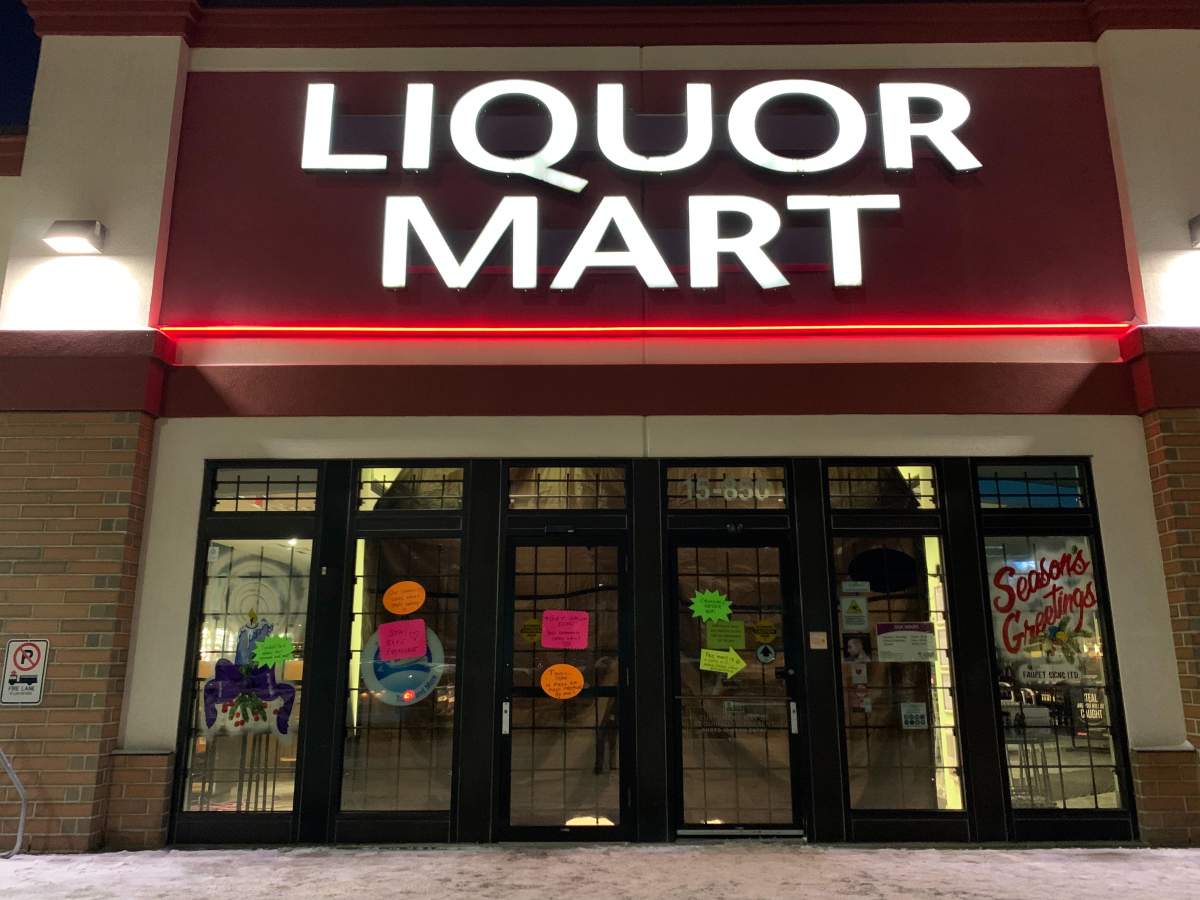 Signs posted on the doors and windows of the Tyndall Park Liquor Mart.