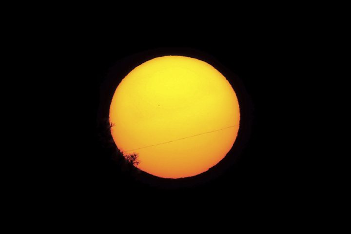 Planet Mercury is seen as a small silhouette, center left, as it travels across the face of the sun, near capital Nicosia, Cyprus, Monday, Nov. 11, 2019.