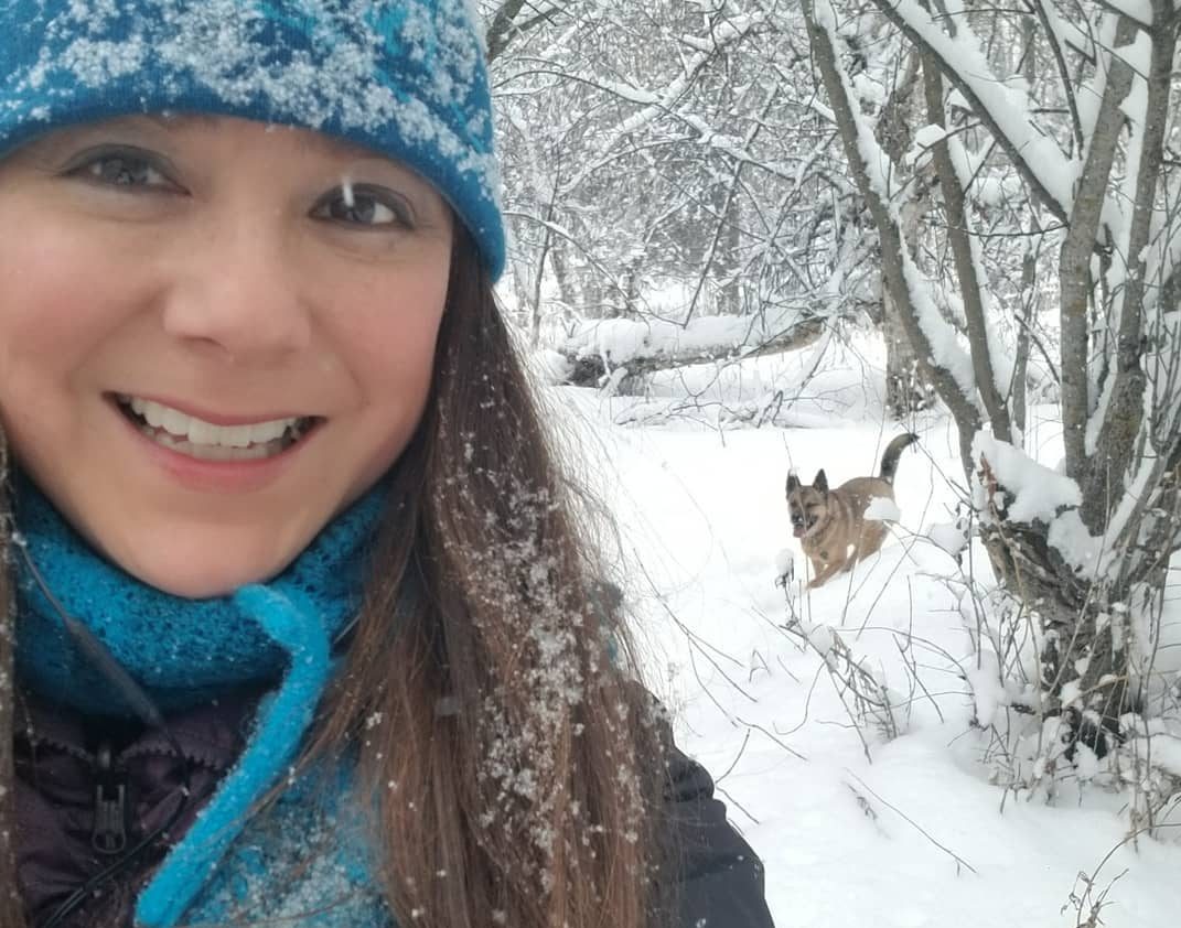 Daintre Christensen and her dog Virgil walking in in the woods.