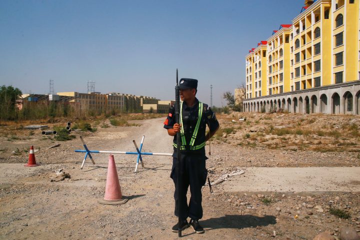 FILE PHOTO: A Chinese police officer takes his position by the road near what is officially called a vocational education centre in Yining in Xinjiang Uighur Autonomous Region, China September 4, 2018.  