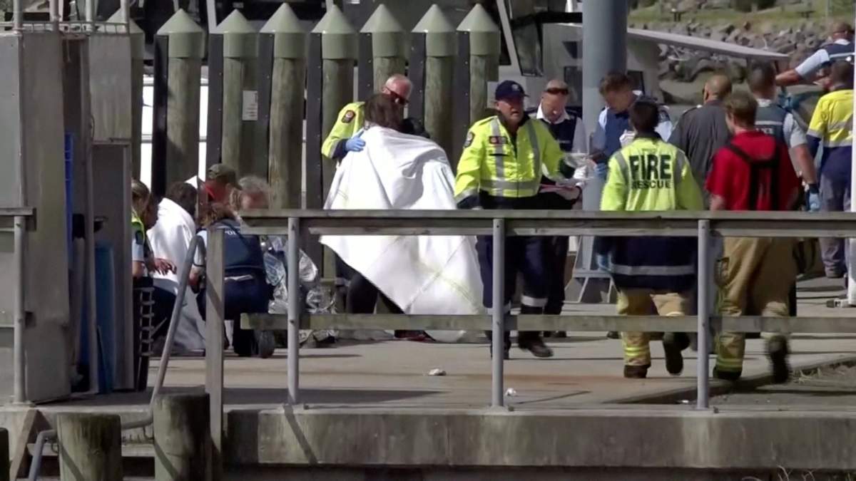 A person wrapped in a blanket is comforted by emergency services personnel following an eruption of the White Island volcano in Whakatane, New Zealand on Dec. 9, 2019, in this still image taken from video.