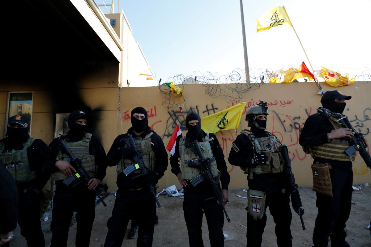Members of Iraqi security forces stand guard as protesters and militia fighters gather to condemn air strikes on bases belonging to Hashd al-Shaabi (paramilitary forces), outside the main gate of the U.S. Embassy in Baghdad, Iraq December 31, 2019.