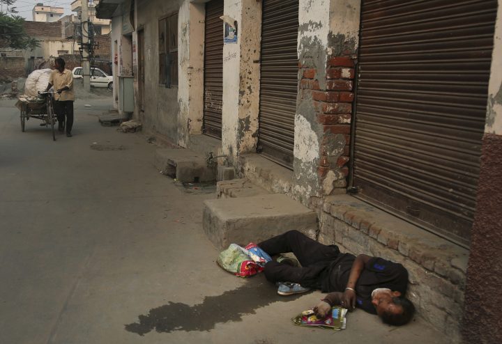 In this Oct. 31, 2019, photo, an Indian drug addict lies unconscious by the side of a road in Kapurthala, in the northern Indian state of Punjab.