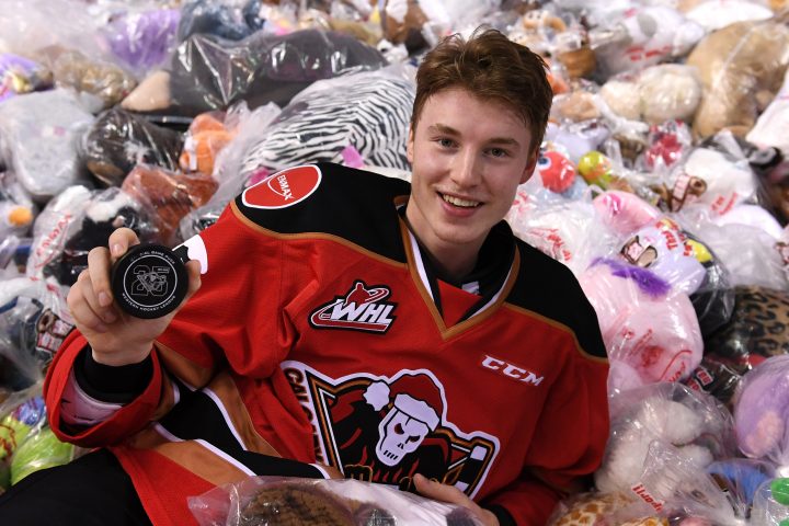 Calgary Hitmen forward Carson Focht lies in a pile of bears holding the goal-scoring puck at the 2019 Teddy Bear Toss on Sunday, Dec. 1, 2019.