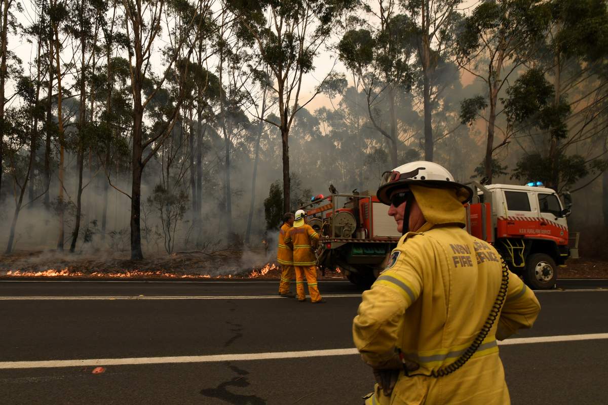 Rural Fire Service volunteers and Fire and Rescue NSW officers contain a small bushfire which closed the Princes Highway south of Ulladulla, Australia, Jan. 5, 2020.