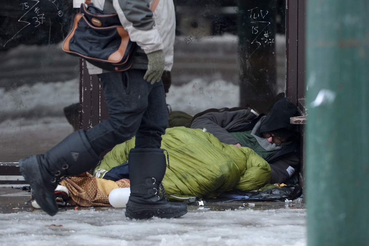 A homeless man sleeps in a doorway in Vancouver's Downtown Eastside, Monday, Dec. 19, 2016. 