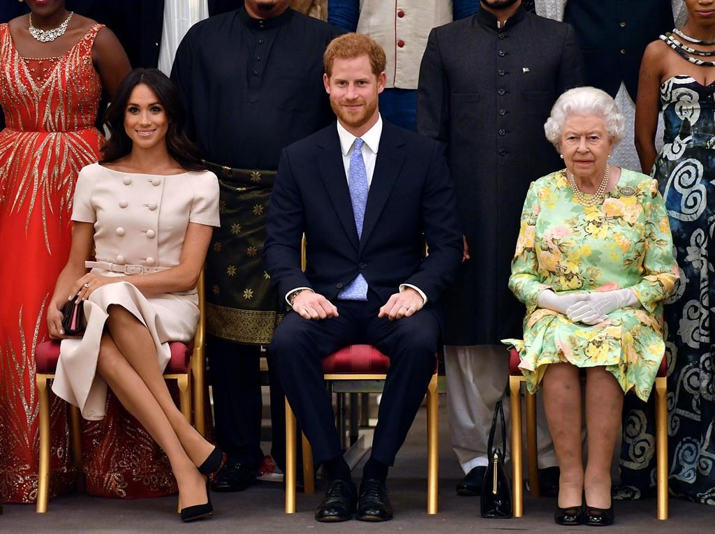 Britain’s Queen Elizabeth, Prince Harry and Meghan, Duchess of Sussex pose for a group photo at the Queen’s Young Leaders Awards Ceremony at Buckingham Palace in London on Tuesday, June 26, 2018.