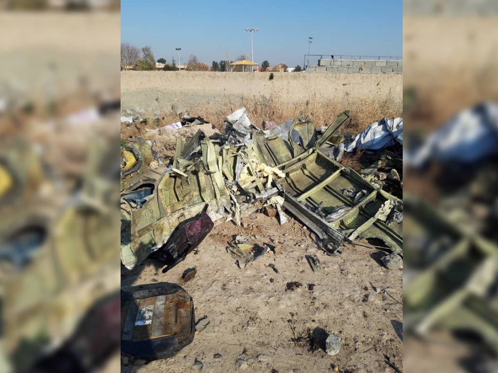 Charred pieces of the are pictured laying on the ground near the crash site.