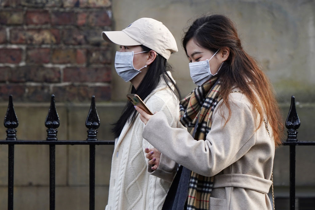 Two women wearing face masks walk through the city centre near the Royal Victoria Infirmary where two patients who have tested positive for the new coronavirus are being treated by specialist medical workers on Jan. 31, 2020 in Newcastle upon Tyne, England.