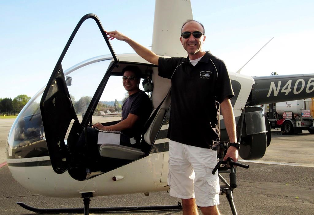 This undated photo provided by Group 3 Aviation shows helicopter pilot Ara Zobayan standing outside a helicopter, at a location not provided. Zobayan was at the controls of the helicopter that crashed in Southern California Sunday, Jan. 26, 2020, killing all nine aboard including former Lakers star Kobe Bryant. The other person inside is unidentified. (Group 3 Aviation via AP)