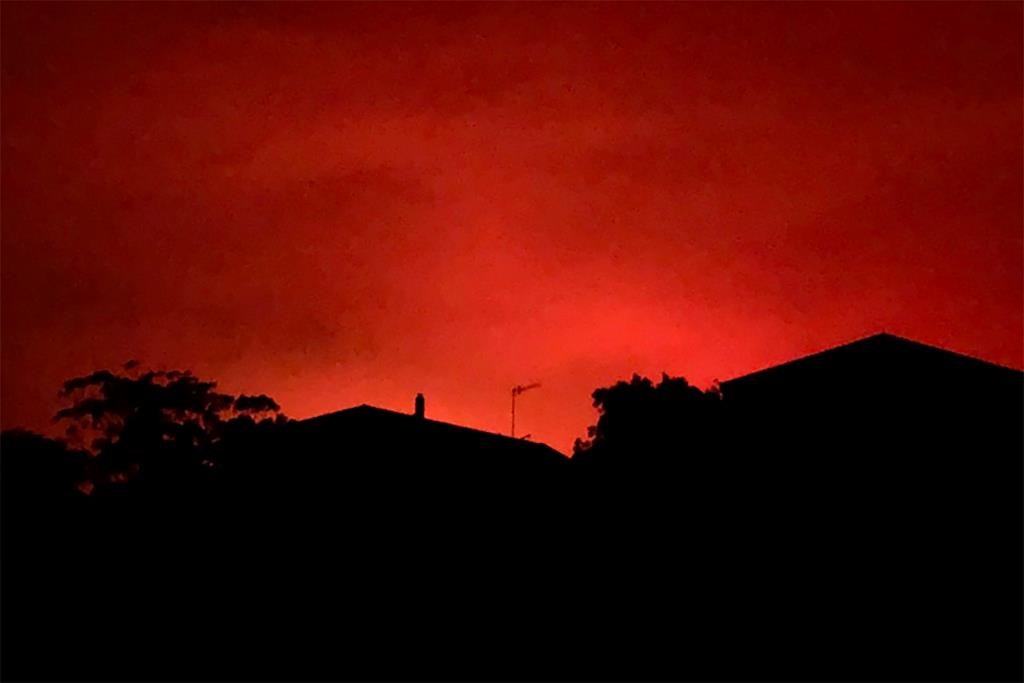 This Tuesday, Dec. 31, 2019, photo provided by Twitter user @AvaTheHuman shows red sky from wildfires burning, in Victoria, Australia. On Tuesday morning, 4,000 people in the coastal town of Mallacoota fled to the shore as winds pushed a fire toward their homes under a sky darkened by smoke and turned blood-red by flames.
