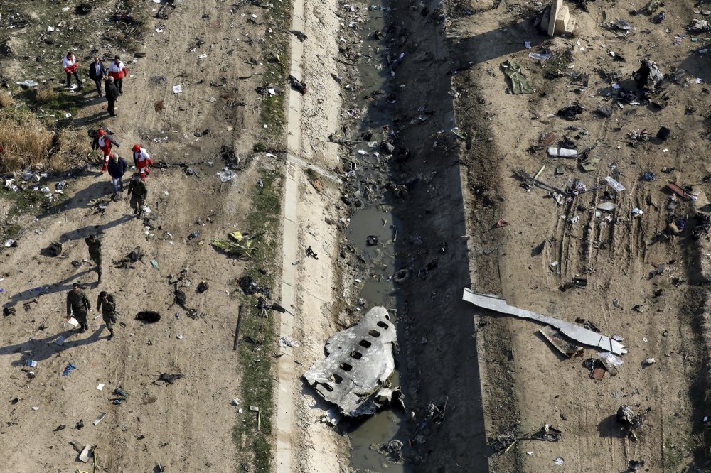 FILE - In this Jan. 8, 2020, file photo, rescue workers search the scene where a Ukrainian plane crashed in Shahedshahr, southwest of Tehran, Iran. The downing of a Ukrainian jetliner near Tehran highlights the limits of the civilian arm of Iran's government against the absolute power of the Shiite theocracy and the paramilitary forces beneath it. 