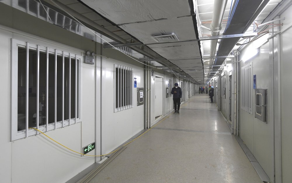 People walk down a corridor at the Huoshenshan temporary field hospital in Wuhan in central China’s Hubei Province, Sunday, Feb. 2, 2020. The Philippines on Sunday reported the first death from a new virus outside of China, where authorities delayed the opening of schools in the worst-hit province and tightened quarantine measures in a city that allow only one family member to venture out to buy supplies.