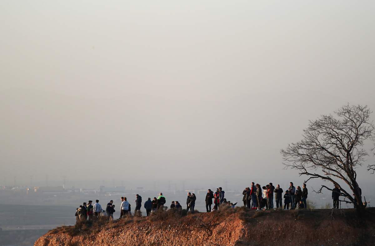 People gather to watch the emergency landing of an Air Canada aircraft at Madrid’s Barajas Airport, in Madrid, Spain Feb. 3, 2020.