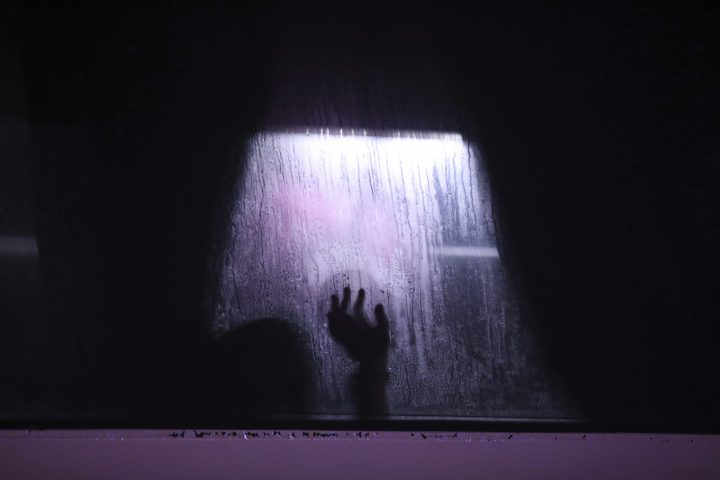 FILE PHOTO: In this Nov. 15, 2019 photo, a migrant puts his hand on the window of a bus in Alvarado, Veracruz state, Mexico. 