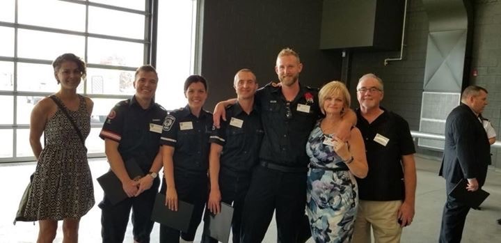 Adam Tapp, with his parents on the right and the crew that saved him on the left at a survivor lunch in London, Ont.