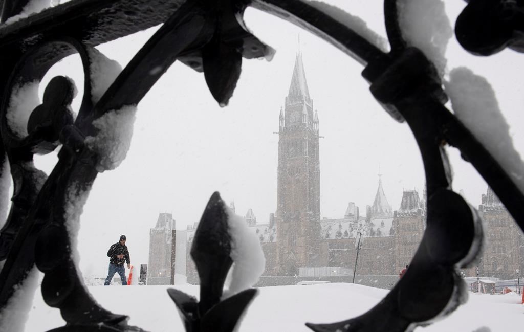 A man walks on Parliament Hill during a snow storm in Ottawa, Thursday, Feb. 27, 2020. Over 25cm of snow was expected to fall on the region as a winter storm passed through.