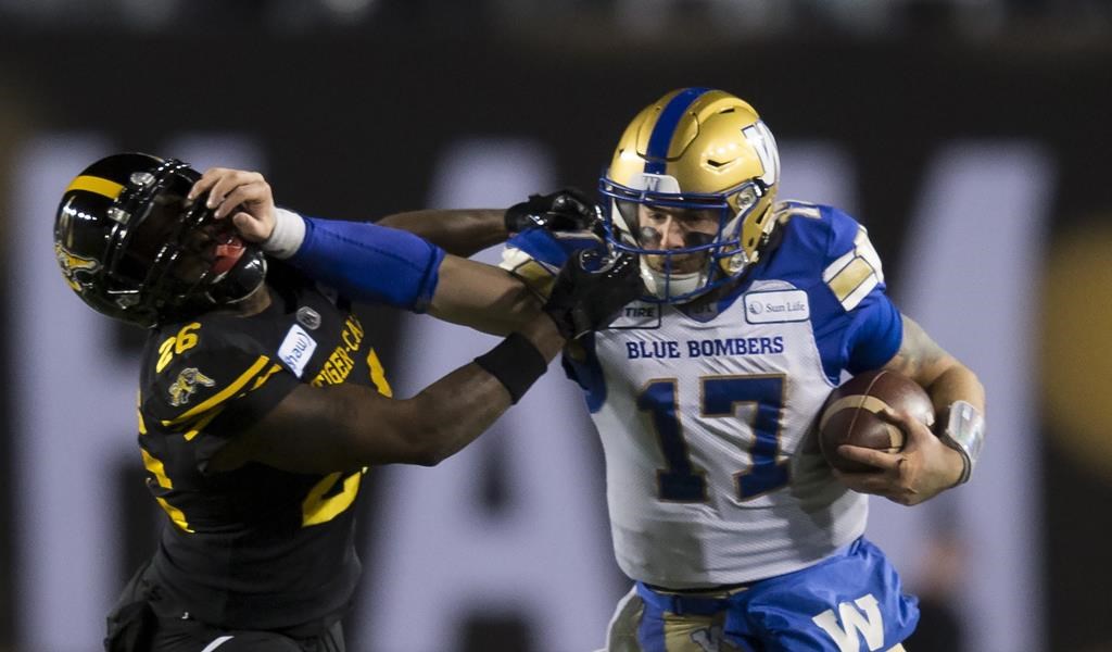 Winnipeg Blue Bombers quarterback Chris Streveler pushes away Hamilton Tiger-Cats' Cariel Brooks during the second half of the 107th Grey Cup in Calgary on November 24, 2019. 