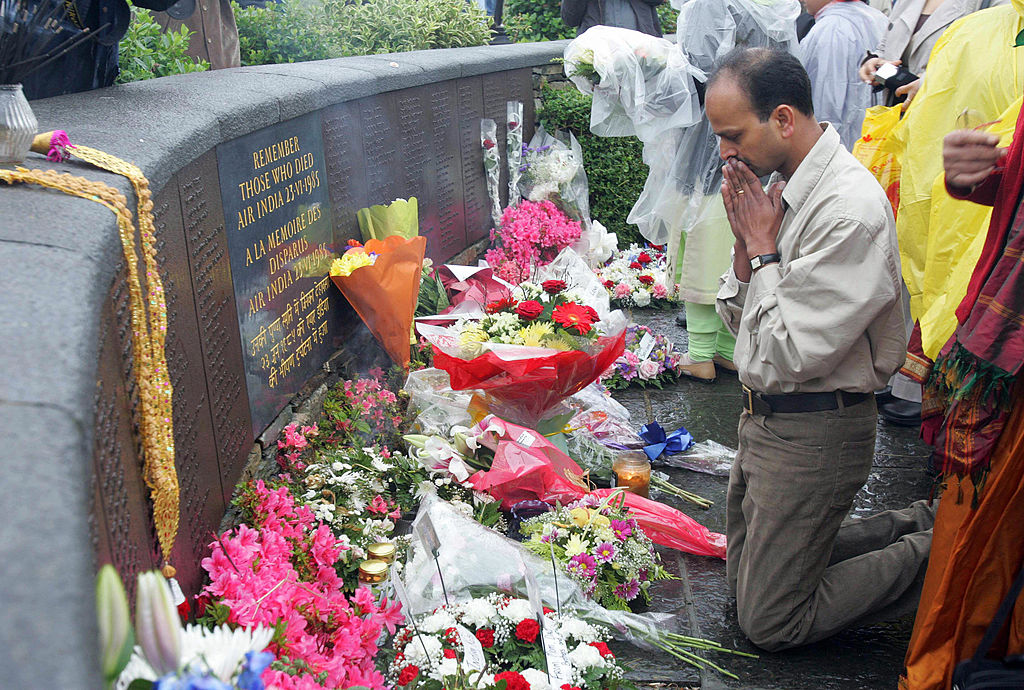 Relatives pray as others lay wreaths at the memorial commemorating the 20th anniversary of the Air India disaster, June 23, 2005 in Ahakista, Cork, Ireland. (Photo by Fran Caffrey/AFP via Getty Images)