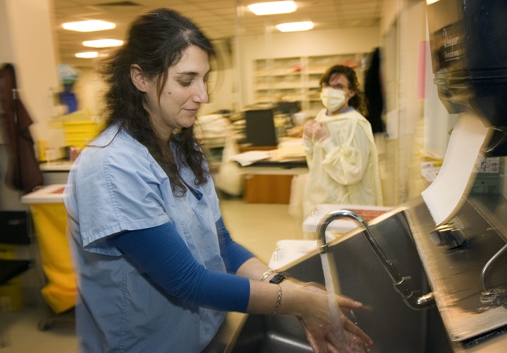 In this file photo, nurse Elana Cohen washes her hands prior to tending to patients as colleague Julie-Anne D'Amico looks on in the intensive care unit at the Montreal Jewish General hospital. The hospital is one of four designated to treat any future patients diagnosed with coronavirus. Friday, Feb. 7, 2020.