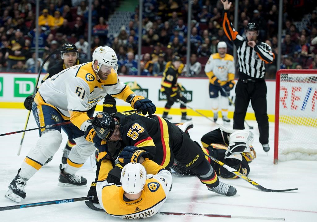 Nashville Predators left wing Austin Watson (51) looks on as Vancouver Canucks centre Bo Horvat (53) puts Nashville Predators centre Colton Sissons (10) to the ice during third period NHL action in Vancouver, Monday, February 10, 2020. THE CANADIAN PRESS/Jonathan Hayward.