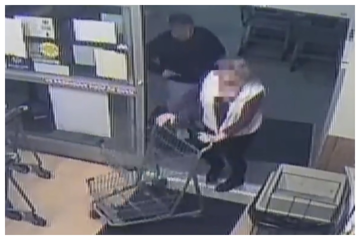 A man is shown holding a suspected syringe before jabbing it into the woman shown at a grocery store in Churchton, Md., on Feb. 18, 2020.