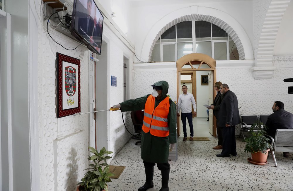 A worker wearing protective gear disinfects the offices at the building of Gaza municipality to help prevent the spread of the new coronavirus, in Gaza City, Tuesday, March 10, 2020. For most people, the new coronavirus causes only mild or moderate symptoms, such as fever and cough. For some, especially older adults and people with existing health problems, it can cause more severe illness, including pneumonia. 
