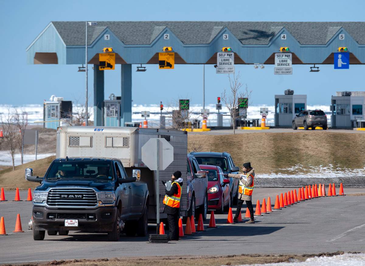 Provincial health department workers stop traffic that has crossed the Confederation Bridge in Borden-Carleton, P.E.I. on Sunday, March 22, 2020.