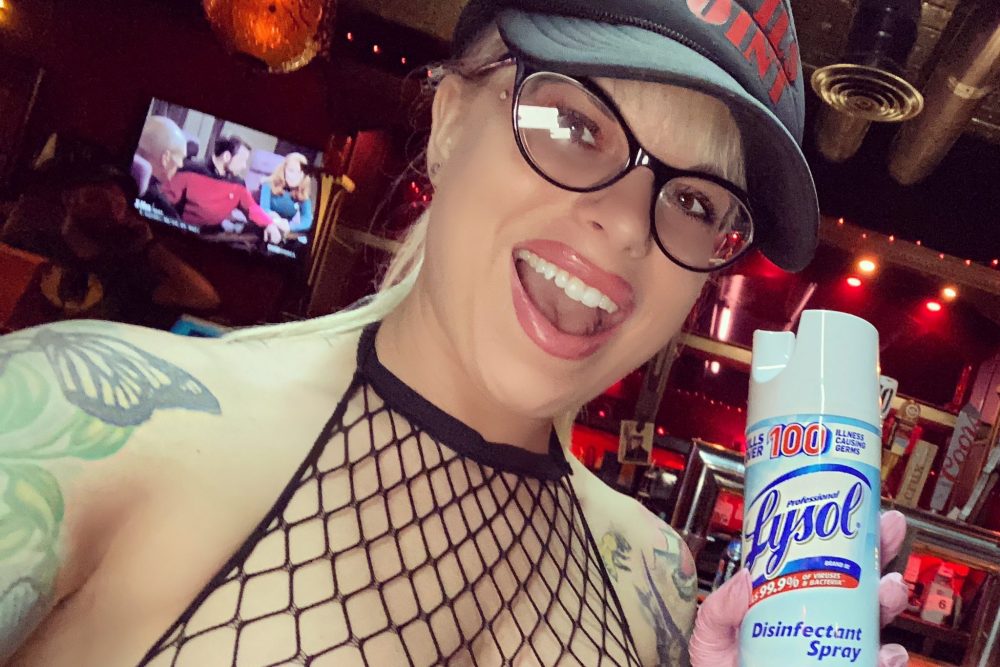 A strip club dancer who calls herself “Toxic the Songful bird” is shown with disinfectant at the Lucky Devil Lounge in Portland, Ore., on March 23, 2020.