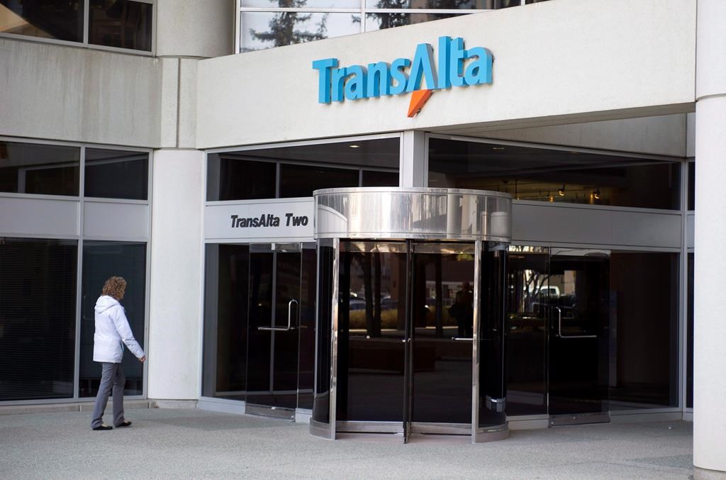 A woman walks towards the entrance of the TransAlta headquarters building in Calgary, on Tuesday, April 29, 2014.
