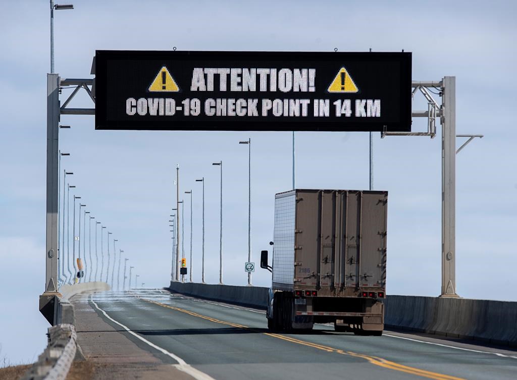 A sign indicates that provincial health department workers will stop traffic that has crossed the Confederation Bridge in Cape Jourimain, N.B. on Sunday, March 22, 2020. Anyone arriving on Prince Edward Island from another province is told to self-isolate for 14 days. This is a step beyond the federal government’s request to those who have travelled internationally. THE CANADIAN PRESS/Andrew Vaughan.