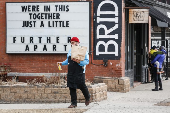 A grocery store clerk brings groceries to a waiting vehicle in Calgary, Alta., Thursday, April 9, 2020, amid the COVID-19 pandemic.