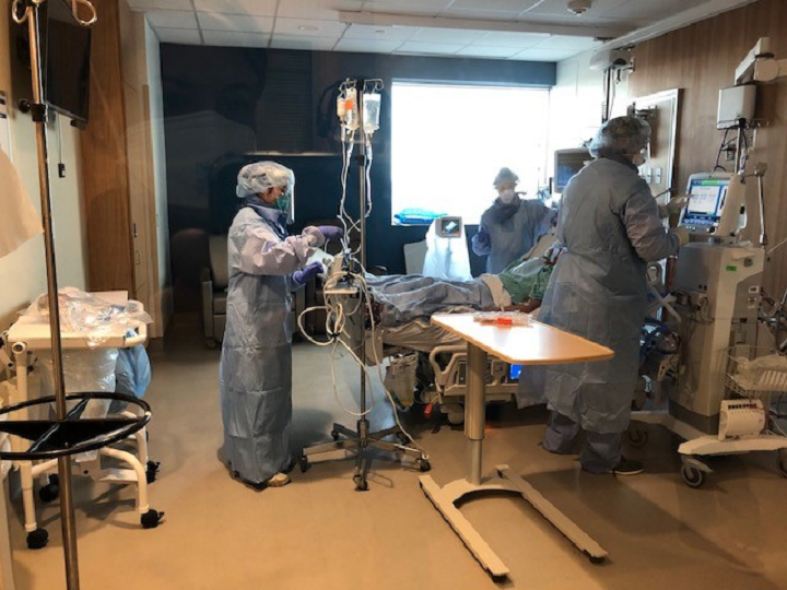 Healthcare workers dressed in personal protective equipment while tending to a patient at Humber River Hospital.
