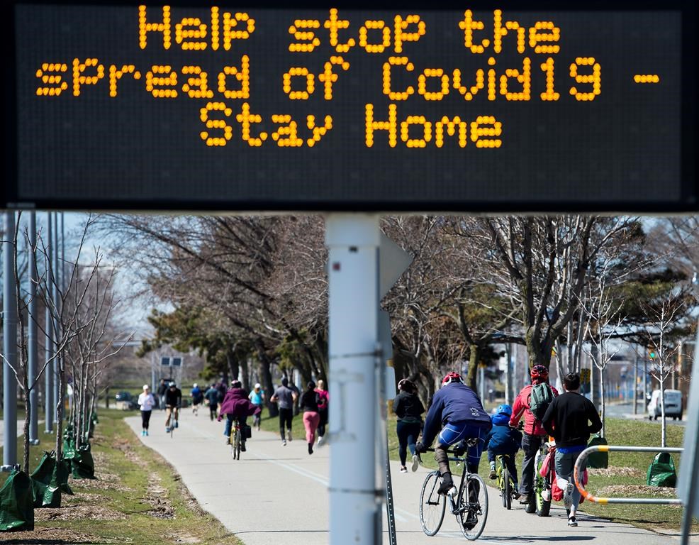 People get exercise outside on the lake shore path along Lake Ontario in Toronto on Thursday, April 2, 2020. Health officials and the government has asks that people stay inside to help curb the spread of the coronavirus also known as COVID-19. THE CANADIAN PRESS/Nathan Denette.