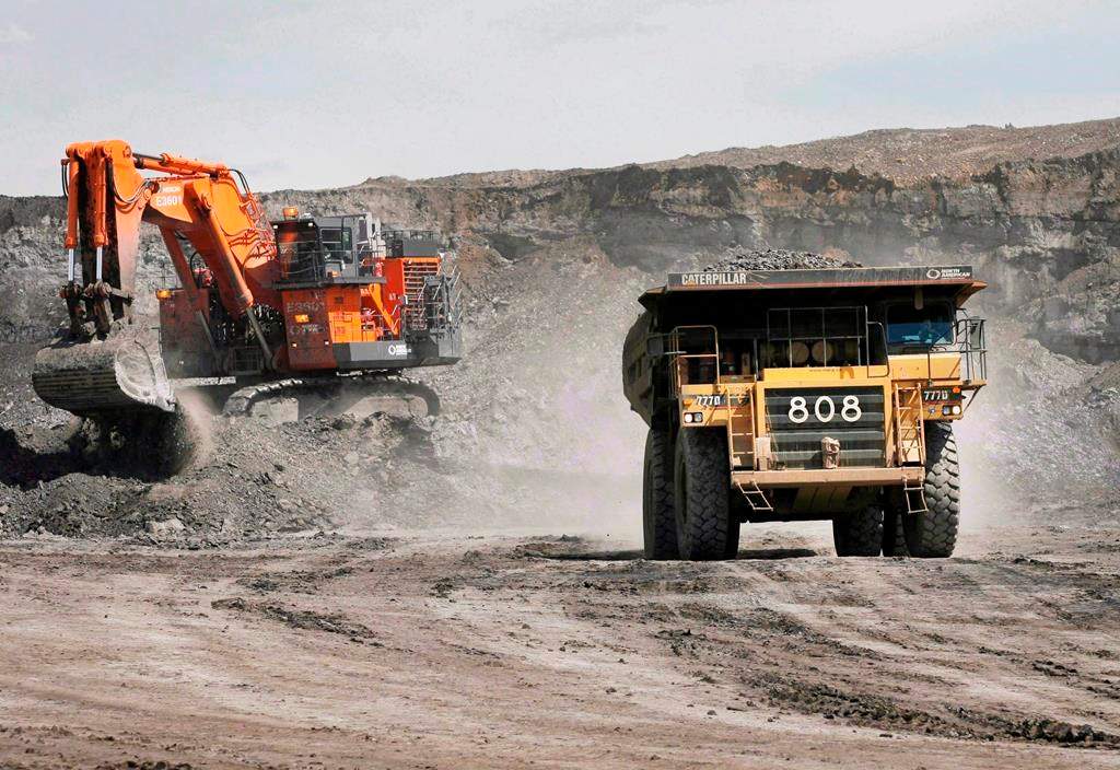 A haul truck carrying a full load drives away from a mining shovel at the Shell Albian Sands oilsands mine near Fort McMurray, Alta., Wednesday, July 9, 2008. 
