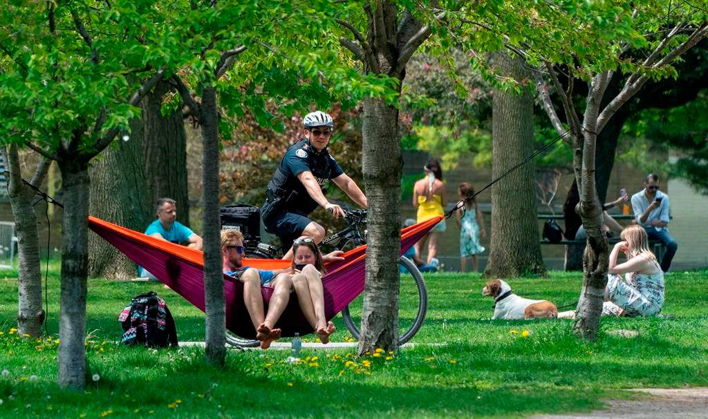A police officer patrols Trinity Bellwoods Park in Toronto on Sunday, May 24, 2020. Warm weather and a reduction in COVID-19 restrictions has many looking to the outdoors for relief. THE CANADIAN PRESS/Frank Gunn