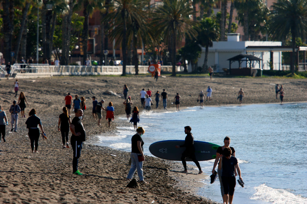 Adults walk and exercise at the beach on the first day that the government allows them to go out for sports individually and to walk with another person with whom they live, at certain times and up to a kilometre away from home on May 2, 2020 in Malaga, Spain.