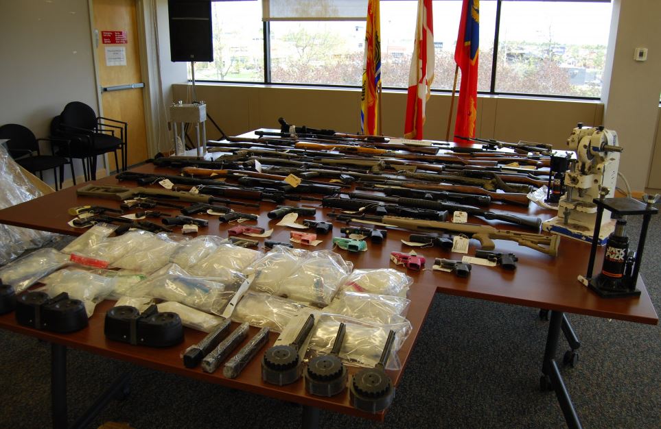 Police say 53 firearms, ammunition, methamphetamine, cocaine and cash was seized from the home. 