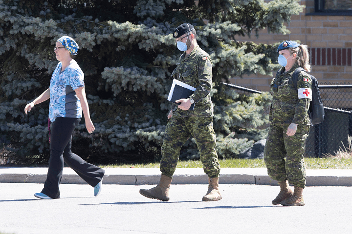 A staff member escorts members of the Canadian Armed Forces in to Orchard Villa Care home, in Pickering, Ont. on Saturday, April 25, 2020.