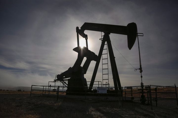 A pumpjack works at a well head on an oil and gas installation near Cremona, Alta., Saturday, Oct. 29, 2016. 