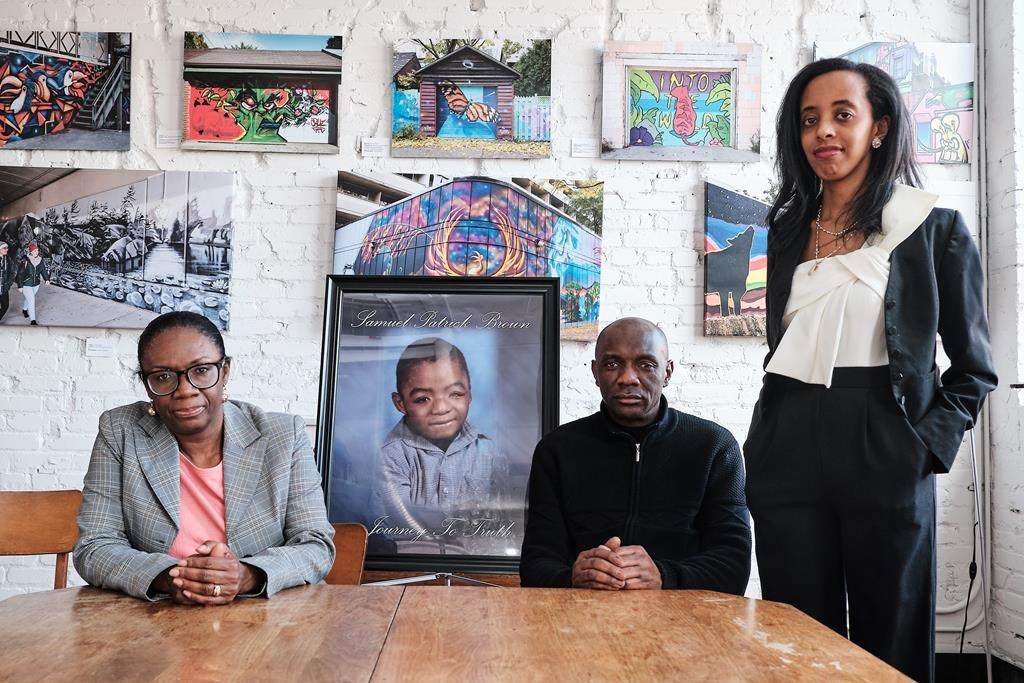 Mother Andrea Brown, father Gladstone Brown and lawyer Saron Gebresellasi (right) are shown with a portrait of Samuel Brown in a handout photo. THE CANADIAN PRESS/HO-Michael YC Tseng