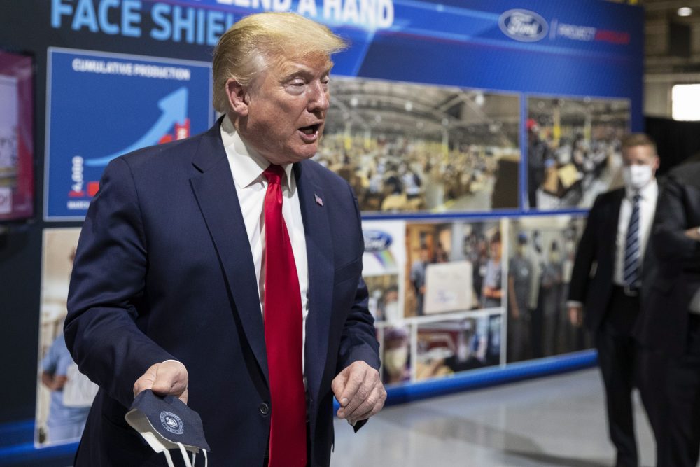 U.S. President Donald Trump holds his protective face mask as he speaks while touring Ford’s Rawsonville components plant that has been converted to make personal protective and medical equipment, Thursday, May 21, 2020, in Ypsilanti, Mich.