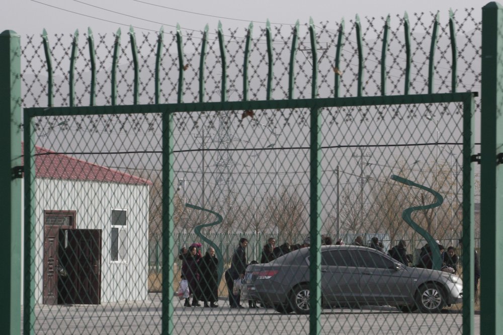 In this Monday, Dec. 3, 2018, file photo, people line up at the Artux City Vocational Skills Education Training Service Center at the Kunshan Industrial Park in Artux in western China’s Xinjiang region. The Associated Press has found that the Chinese government is carrying out a birth control program aimed at Uighurs, Kazakhs and other largely Muslim minorities in Xinjiang, even as some of the country’s Han majority is encouraged to have more children. The measures include detention in prisons and camps, such as this facility in Artux, as punishment for having too many children.