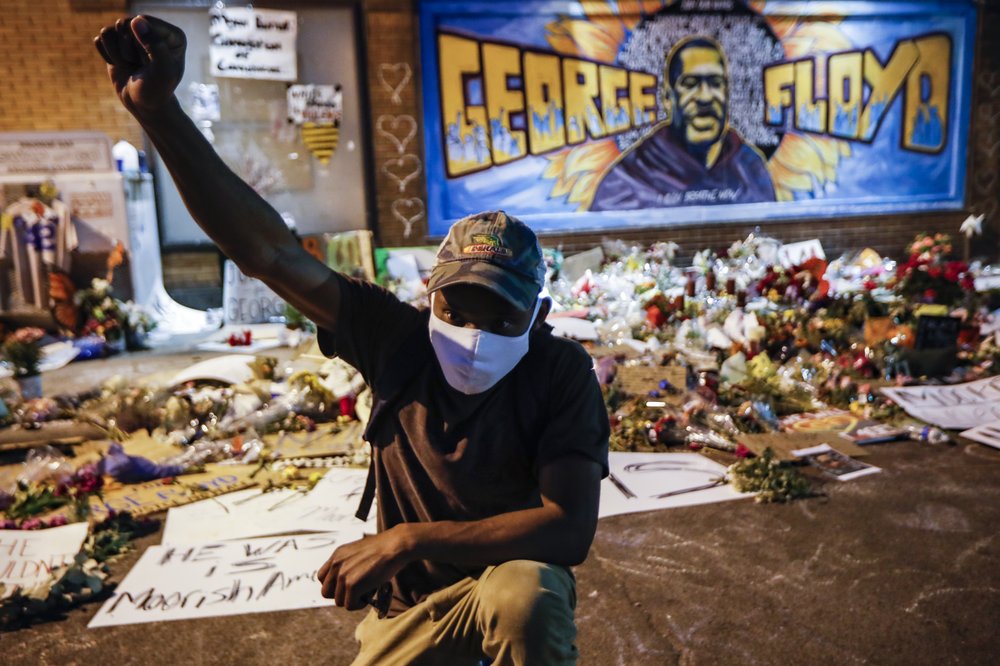 FILE - In this Monday, June 1, 2020 file photo, protesters gather at a memorial for George Floyd where he died outside Cup Foods on East 38th Street and Chicago Avenue in Minneapolis. Floyd died after being restrained by Minneapolis police officers on May 25. The deaths of Floyd and other black men at the hands of Minneapolis police have exacerbated the corrosive relationship between people of color and a criminal justice system they feel is stacked against them. 