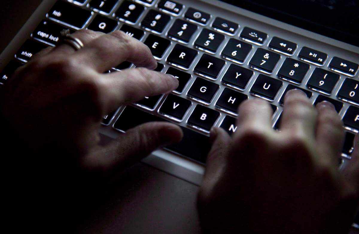 A woman uses her computer keyboard to type while surfing the internet in North Vancouver on December 19, 2012.