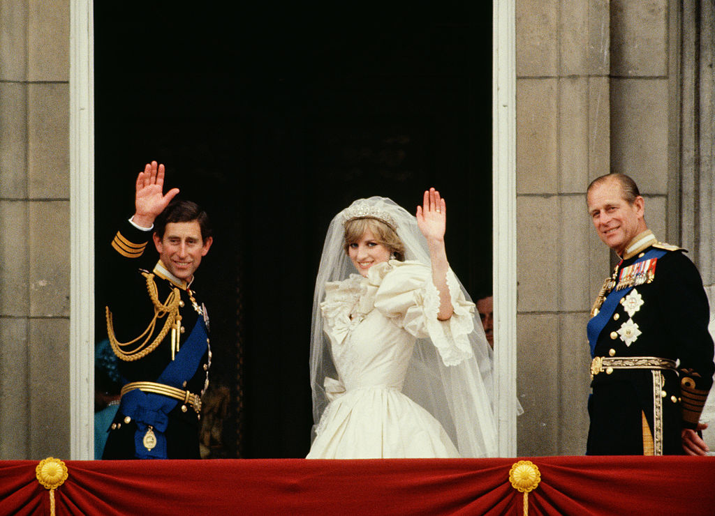 Princess Diana and Prince Charles wave from the Buckingham Palace balcony on their wedding day, sided by Prince Philip.