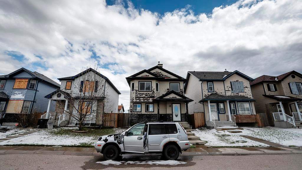 Residents survey the damage before begining cleanup in Calgary, Alta., Sunday, June 14, 2020, after a major hail storm damaged homes and flooded streets on Saturday.