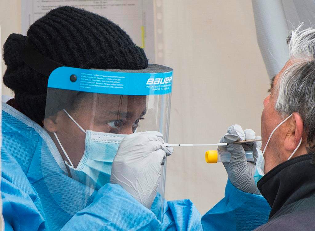 A health-care worker prepares to swab a man at a walk-in coronavirus test clinic.