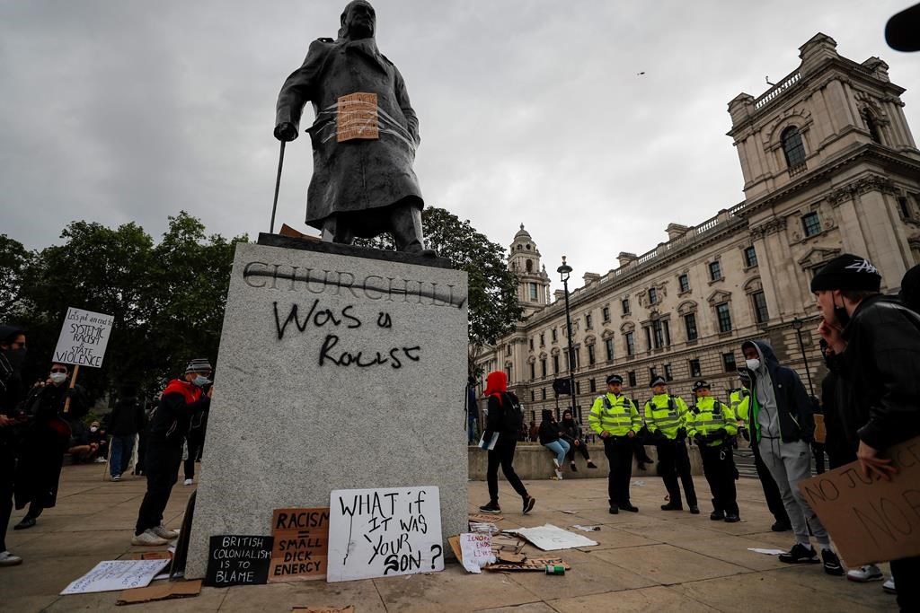 Protesters and police gather around Winston Churchill statue in Parliament Square during the Black Lives Matter protest rally in London, Sunday, June 7, 2020. (AP Photo/Frank Augstein)