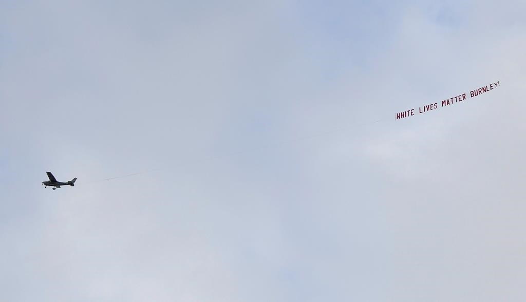 A plane towing a banner reading White Lives Matter Burnley flies above the stadium during the English Premier League soccer match between Manchester City and Burnley at Etihad Stadium, in Manchester, England, on June 22, 2020. (AP Photo/Michael Regan/Pool)